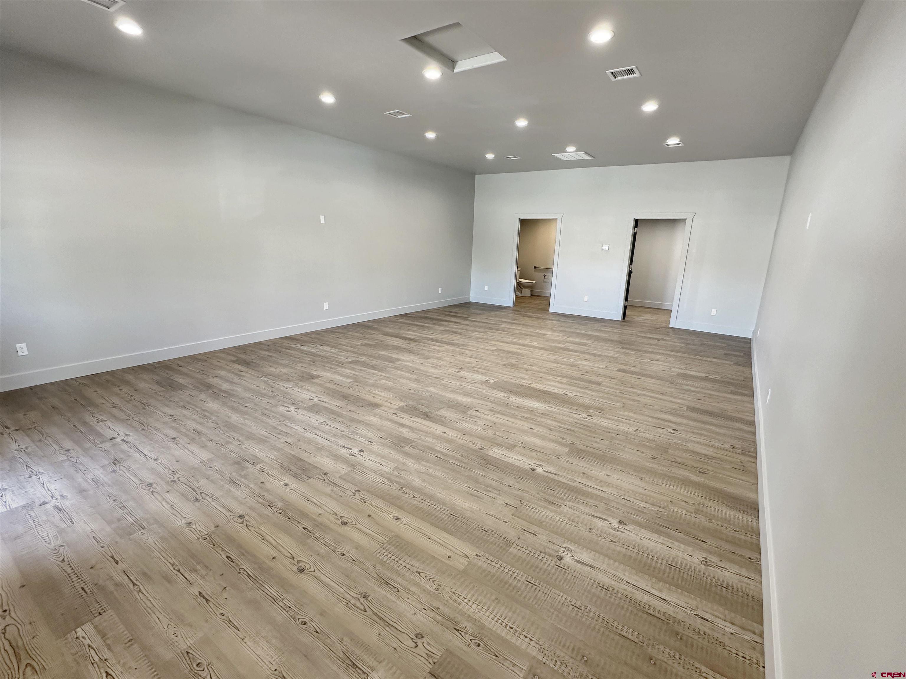 1110 Railroad Avenue, Unit C Dolores, CO 81323 - Photo 6 of 6 an empty room with wooden floor and windows