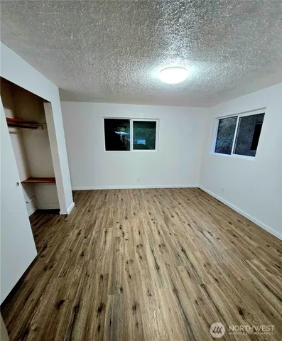 a view of empty room with wooden floor