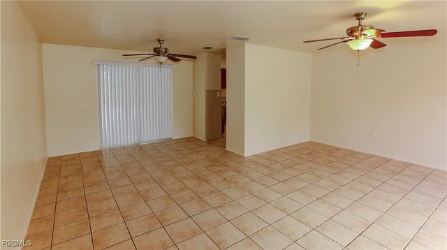 an empty room with a window and a ceiling fan