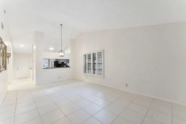 a view of an empty room and kitchen view