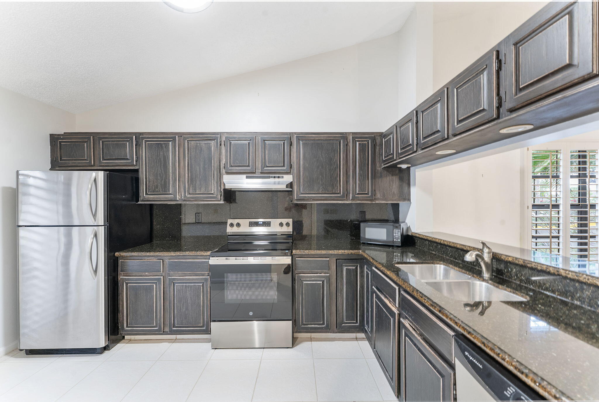 3088 Inglewood Terrace Boca Raton, FL 33431 - Photo 4 of 30 a kitchen with stainless steel appliances granite countertop a sink stove refrigerator and cabinets