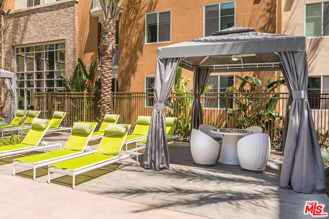 7290 Edinger Avenue, Unit 3131 Huntington Beach, CA 92647 - Photo 16 of 24 a view of a patio with a dining table and chairs