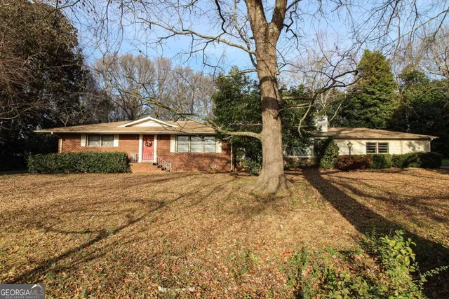 a front view of a house with a yard and shrubs