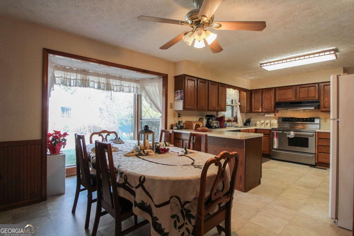 921 Highway 72 Comer, GA 30629 - Photo 15 of 55 a kitchen with a dining table chairs stainless steel appliances and cabinets