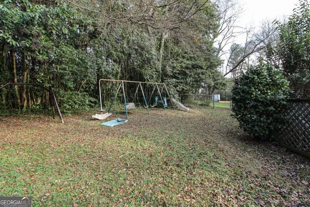 a view of a yard with plants and trees