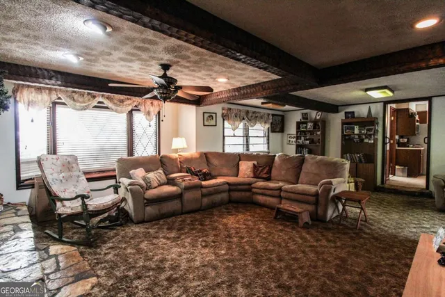 a living room with fireplace furniture and a large window