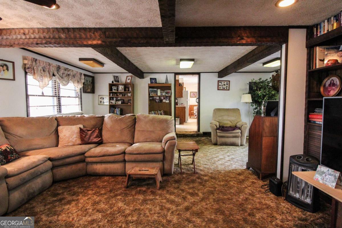 921 Highway 72 Comer, GA 30629 - Photo 9 of 55 a living room with furniture a flat screen tv and a floor to ceiling window