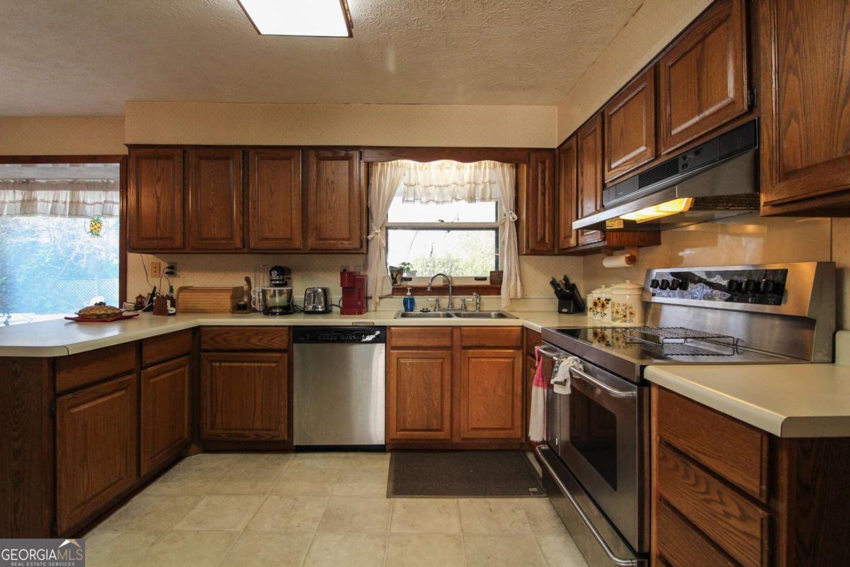 921 Highway 72 Comer, GA 30629 - Photo 10 of 55 a kitchen with stainless steel appliances granite countertop a sink stove and cabinets