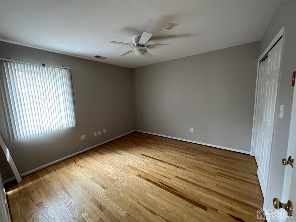 59 Winthrop Road, Unit 59A Monroe Township, NJ 08831 - Photo 10 of 13 an empty room with wooden floor fan and windows