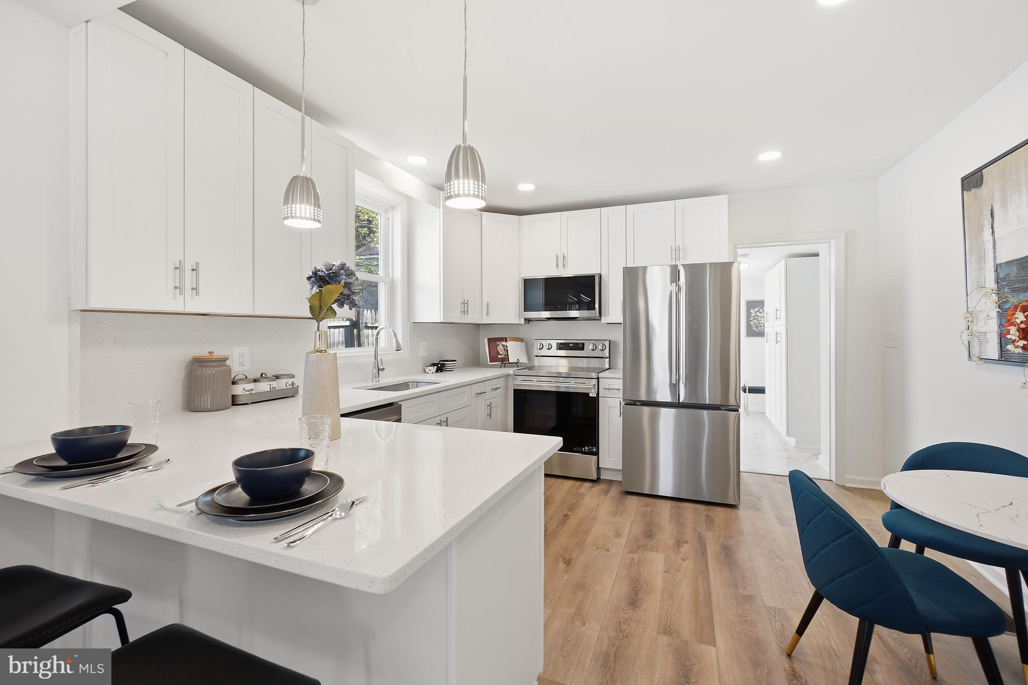 3731 Falls Road Baltimore, MD 21211 - Photo 6 of 30 a kitchen with stainless steel appliances a stove a refrigerator a sink a dining table and chairs