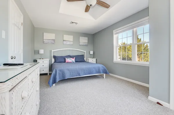 a bedroom with a bed a flat screen tv and a window