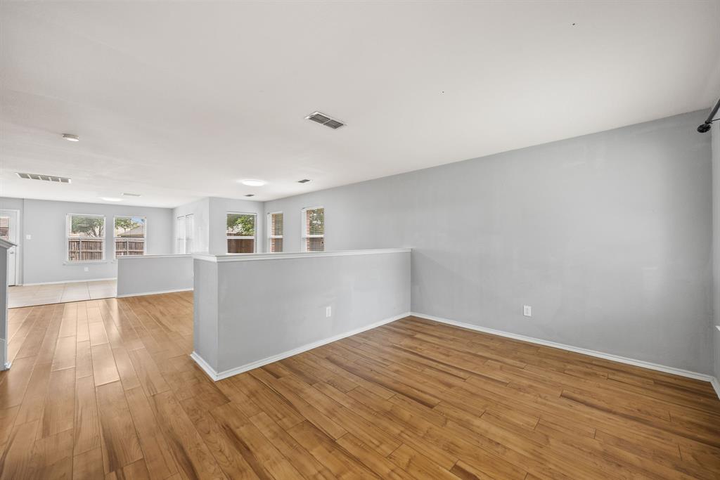 601 Amy Way Euless, TX 76039 - Photo 8 of 40 a view of empty room with wooden floor and kitchen view