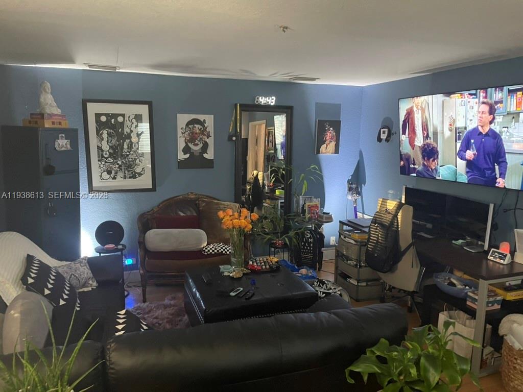 3741 Southwest 27th Terrace Miami, FL 33134 - Photo 11 of 17 a living room with furniture a flat screen tv and a fireplace