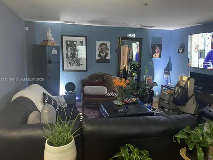 a living room with furniture flowerpot and wooden floor