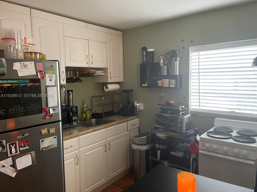 3741 Southwest 27th Terrace Miami, FL 33134 - Photo 14 of 17 a kitchen with sink cabinets and stove top oven