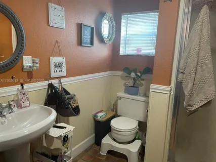 a bathroom with a sink mirror and toilet