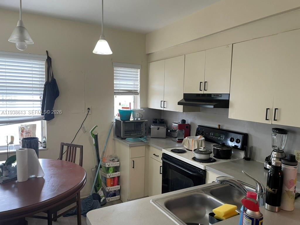 3741 Southwest 27th Terrace Miami, FL 33134 - Photo 6 of 17 a kitchen with a stove a sink and a refrigerator