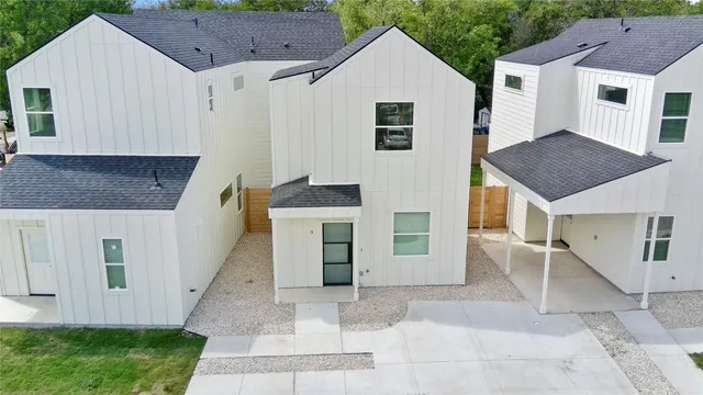 a view of a white house with a sink and a yard