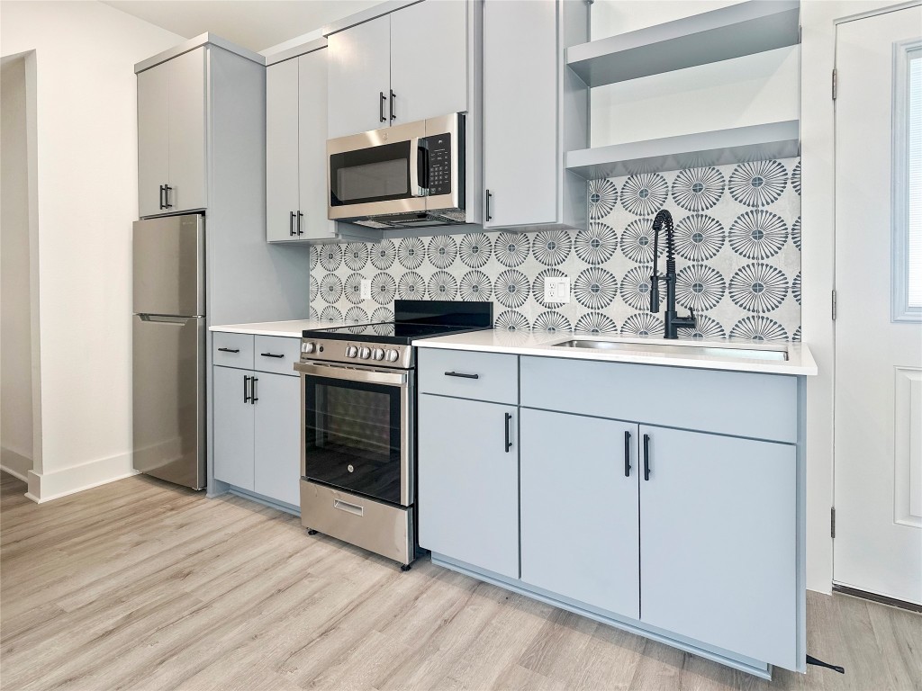 6107 Begonia Circle, Unit 3 Austin, TX 78741 - Photo 7 of 21 a kitchen with cabinets stainless steel appliances and wooden floor