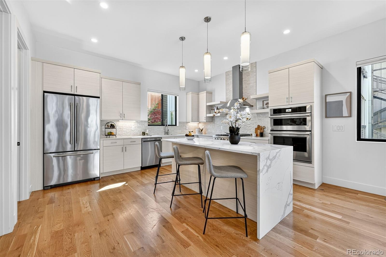 1150 26th Street Denver, CO 80205 - Photo 3 of 50 a kitchen with stainless steel appliances a refrigerator a stove a sink dishwasher and a dining table with wooden floor