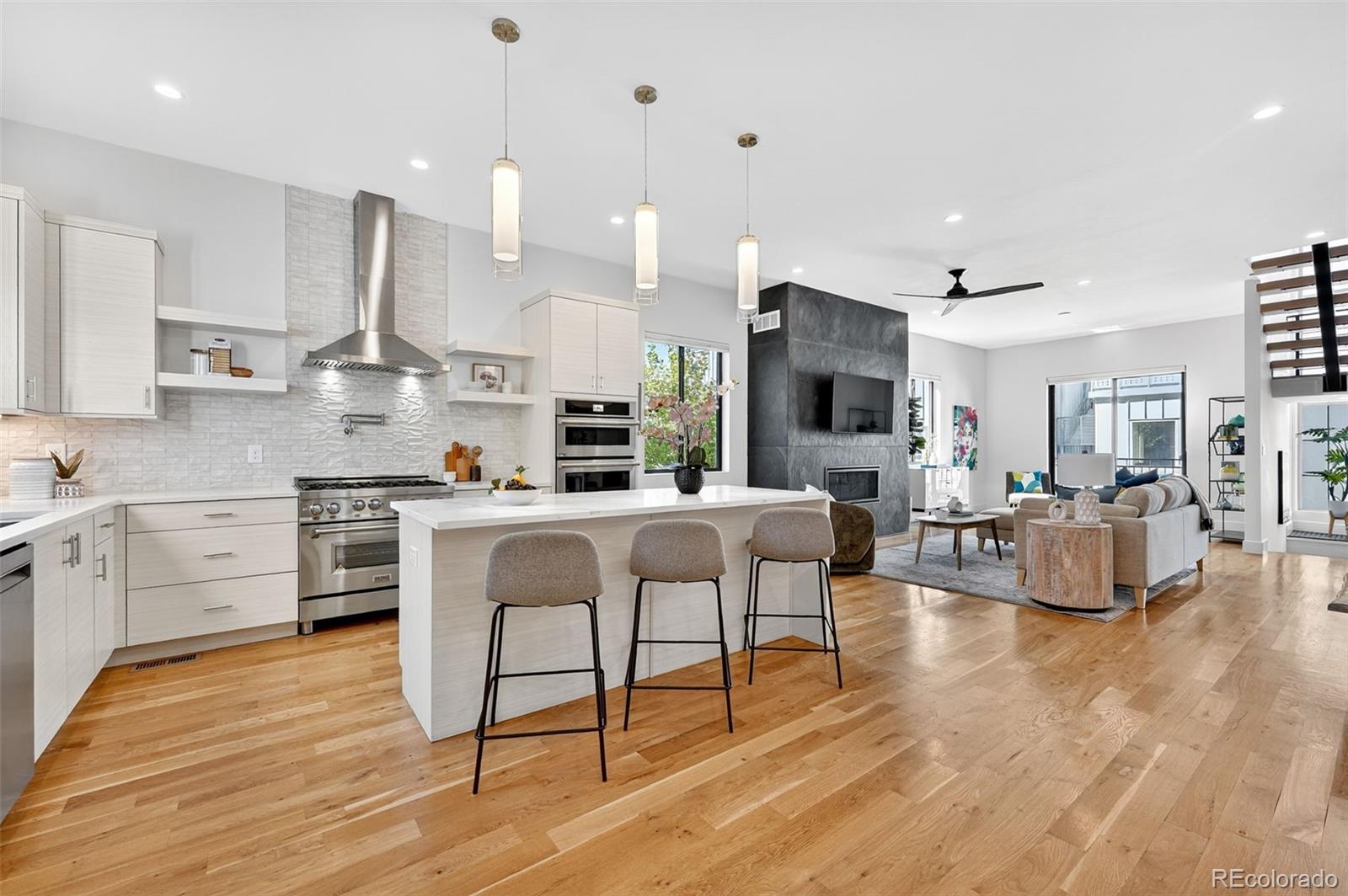 1150 26th Street Denver, CO 80205 - Photo 4 of 50 a kitchen with stainless steel appliances kitchen island granite countertop a stove a sink a refrigerator and white cabinets with wooden floor