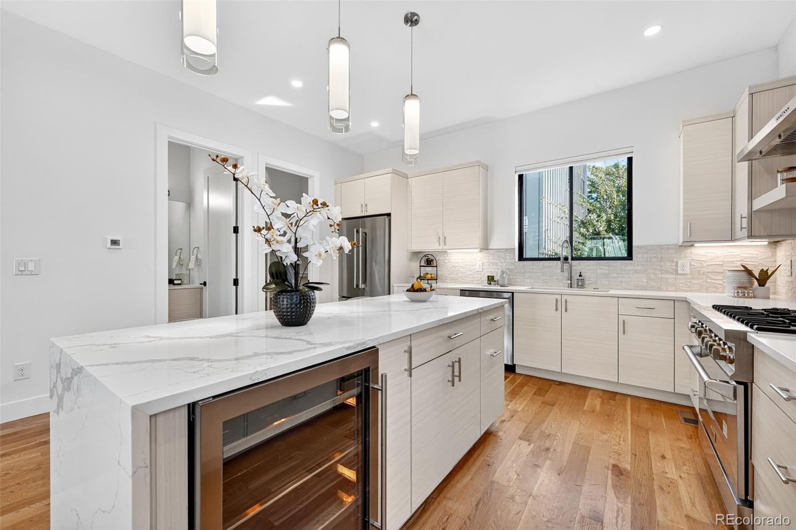 1150 26th Street Denver, CO 80205 - Photo 5 of 50 a kitchen with a sink dishwasher a stove a dining table and chairs with wooden floor