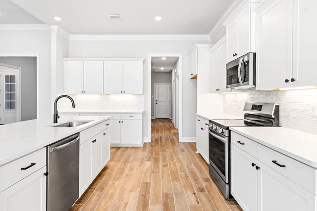 a kitchen with stainless steel appliances a sink dishwasher stove refrigerator and microwave