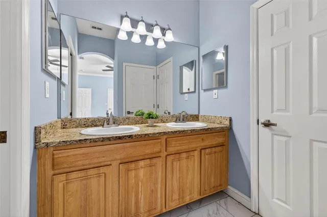 a bathroom with a granite countertop sink a large mirror and a
