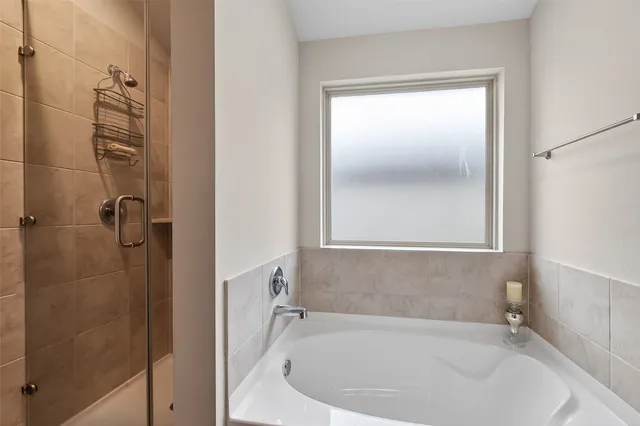 a bathroom with a tub double sink and mirror