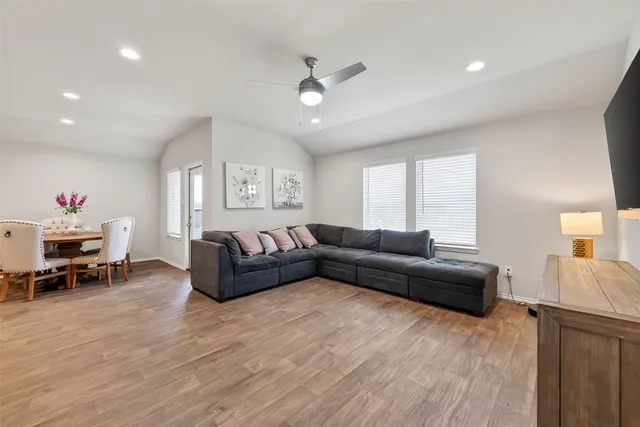 a living room with furniture and a wooden floor