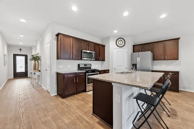 a kitchen with a table chairs refrigerator and microwave