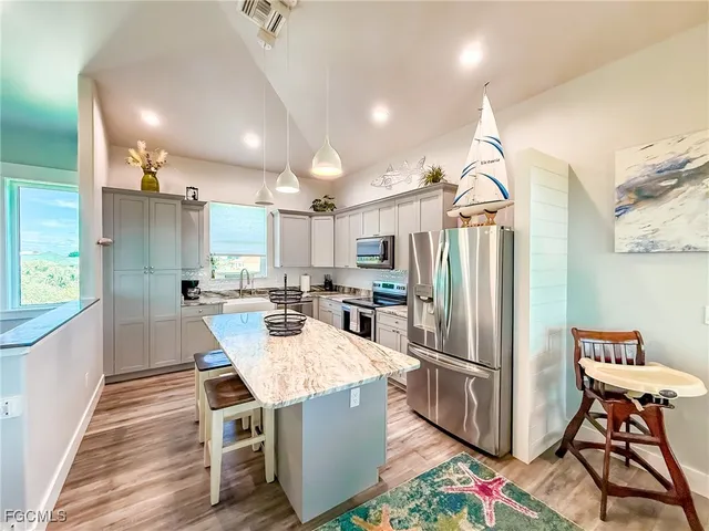 a kitchen with stainless steel appliances granite countertop a refrigerator and a stove