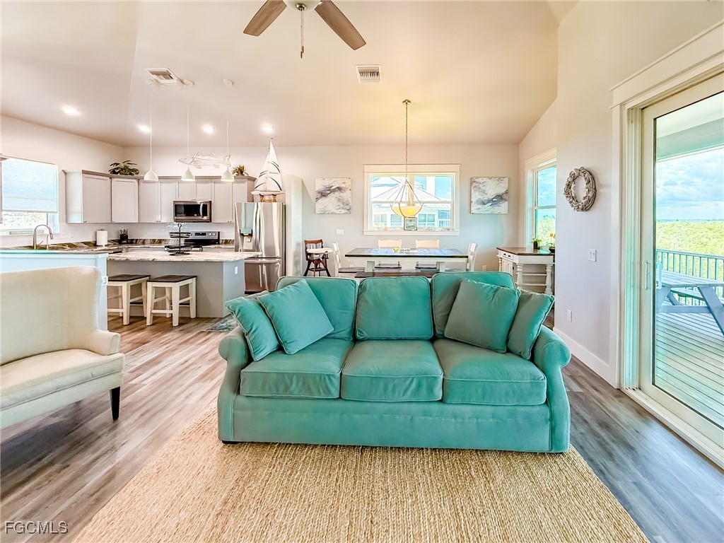 631 Rum Road Upper Captiva, FL 33924 - Photo 34 of 50 a living room with stainless steel appliances furniture wooden floor and a kitchen view