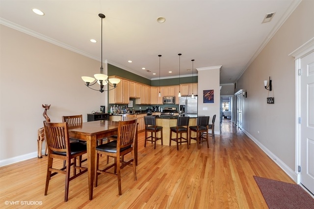 3747 North Clark Street, Unit 2N Chicago, IL 60613 - Photo 4 of 10 a view of a dining room and livingroom with furniture wooden floor a chandelier