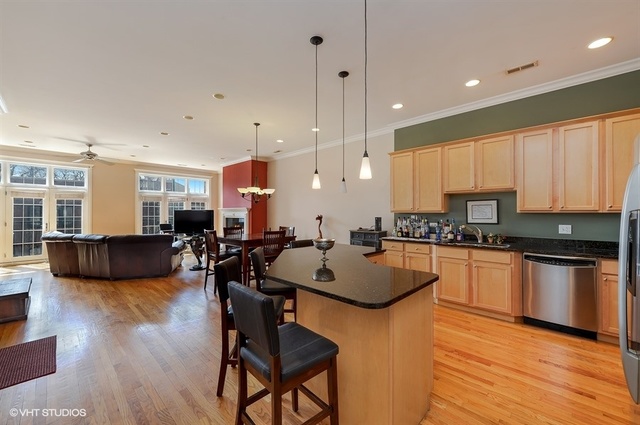 3747 North Clark Street, Unit 2N Chicago, IL 60613 - Photo 5 of 10 a kitchen with stainless steel appliances granite countertop wooden cabinets a stove a sink a dining table and chairs