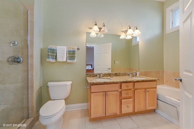 3747 North Clark Street, Unit 2N Chicago, IL 60613 - Photo 7 of 10 a bathroom with a granite countertop toilet sink and mirror