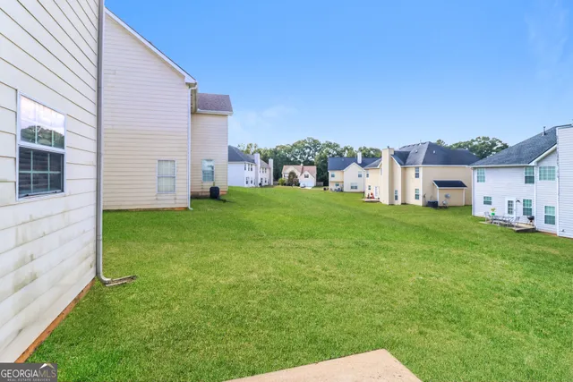 a view of a house with a yard and sitting area