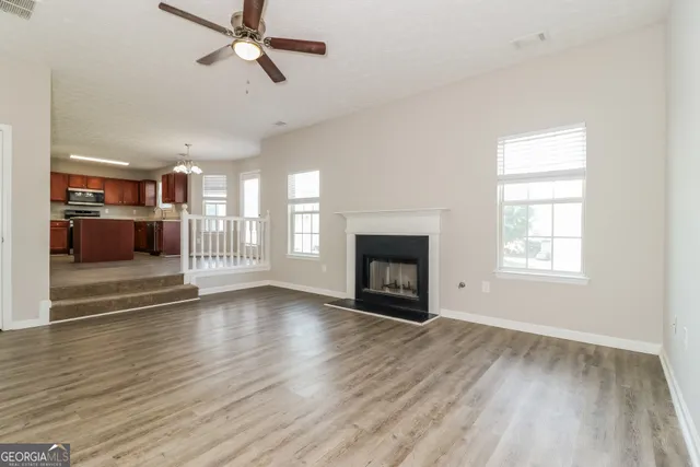 a view of empty room with wooden floor and fireplace
