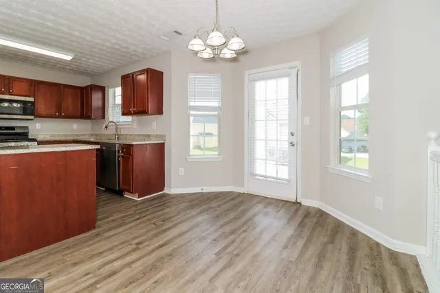 a view of kitchen with granite countertop cabinets stainless steel appliances and a window