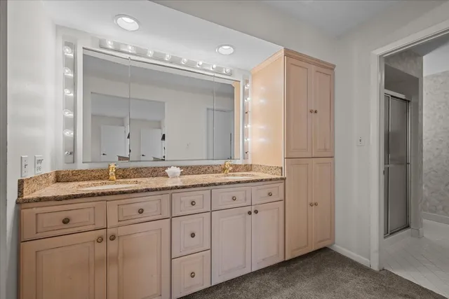 a bathroom with a granite countertop sink two mirror and a