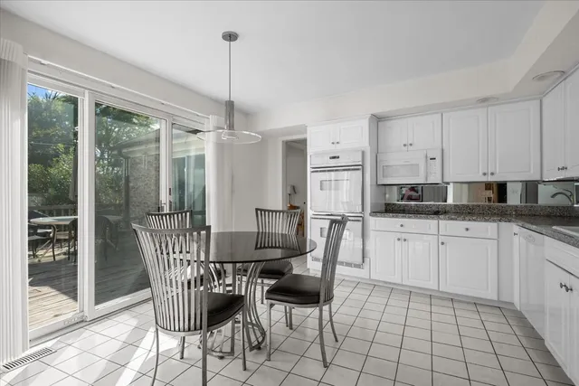 a dining room with furniture a chandelier and kitchen view