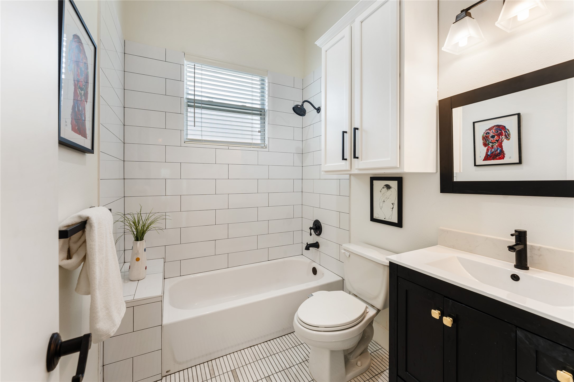415 West 8th Street Houston, TX 77007 - Photo 34 of 39 Beautifully updated with timeless finishes, the secondary bath features sleek white subway tile, quartz countertops, and striking matte black fixtures. Clean lines and designer details create a fresh, sophisticated space for family and guests alike. Every renovation reflects the home's commitment to quality and enduring style.