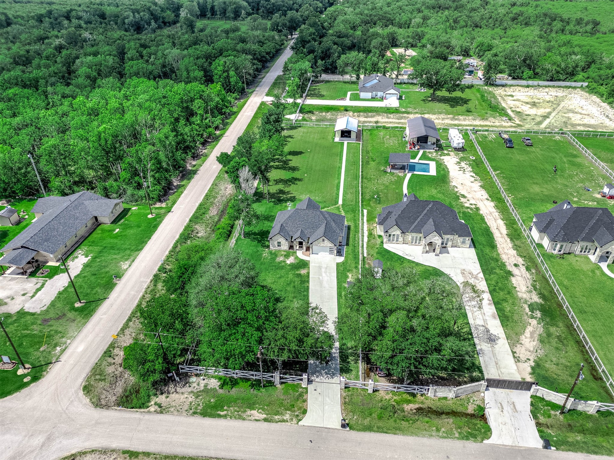 8032 Short Road Needville, TX 77461 - Photo 3 of 50 An aerial perspective showcasing the full layout of the property, including the extended driveway, surrounding landscape, and overall footprint of the home and land. This view gives a great sense of the space, setting, and positioning of the property within the area.
