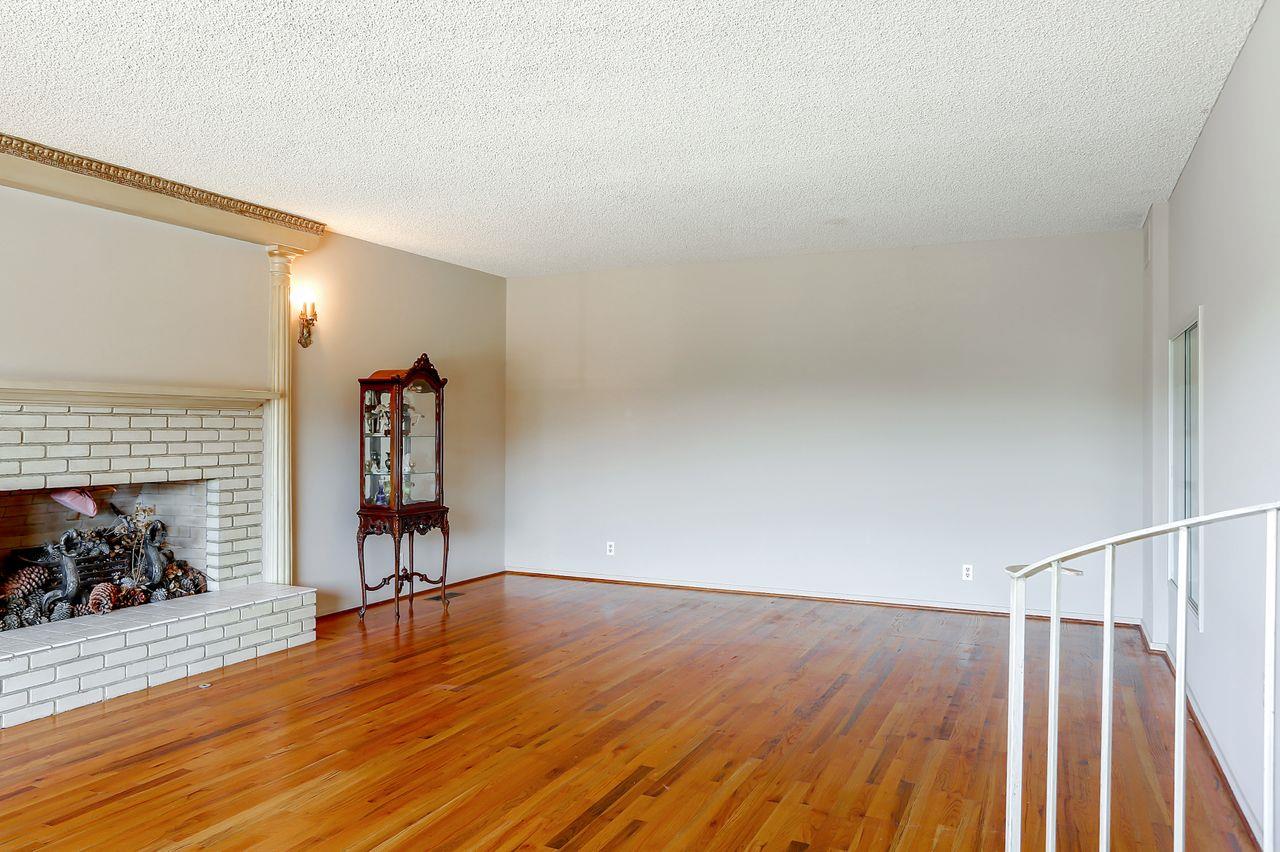 3235 Rio Road Carmel, CA 93923 - Photo 15 of 40 a view of empty room with wooden floor and fireplace