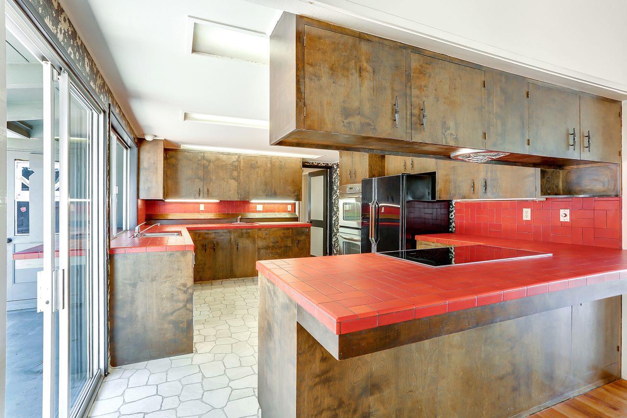 3235 Rio Road Carmel, CA 93923 - Photo 20 of 40 a kitchen with stainless steel appliances kitchen island granite countertop a refrigerator and cabinets