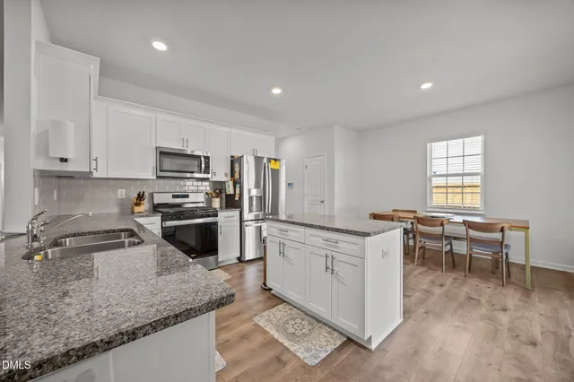 a kitchen with microwave a stove and white cabinets