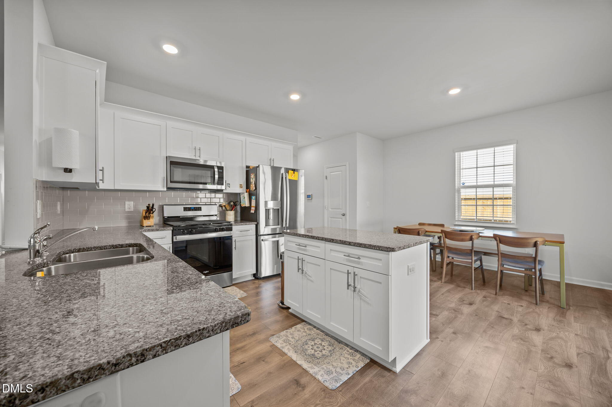 2117 Fletchers Ridge Drive Durham, NC 27703 - Photo 16 of 46 a kitchen with microwave a stove and white cabinets