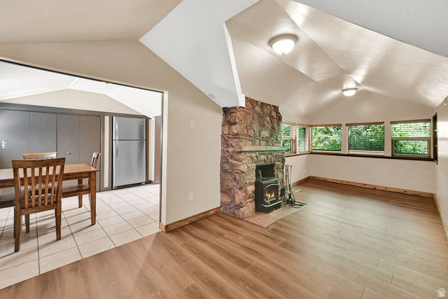 655 Ogden Canyon Road Ogden, UT 84401 - Photo 16 of 50 Living area featuring a stone fireplace with a wood-burning stove insert, wood-finish flooring, and multiple windows