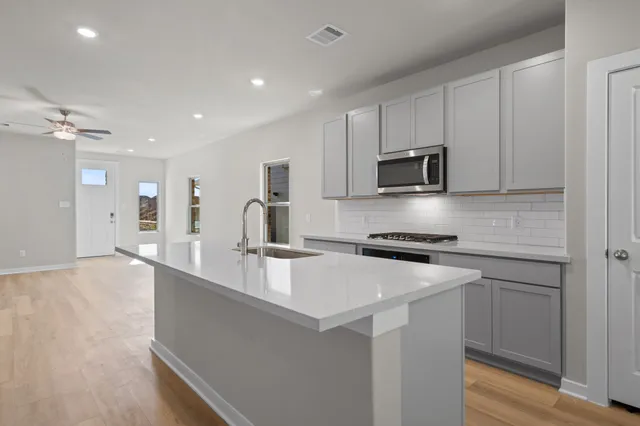 a kitchen with stainless steel appliances granite countertop a stove a sink and a refrigerator