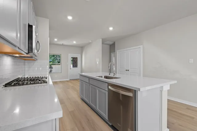 a kitchen with stainless steel appliances a sink stove and cabinets